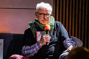 Krzysztof Deszczyński na żółtej sofie w Książnicy Beskidzkiej