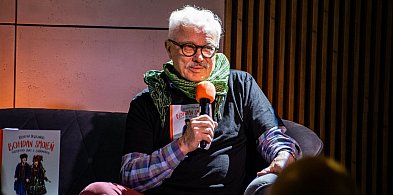 Krzysztof Deszczyński na żółtej sofie w Książnicy Beskidzkiej