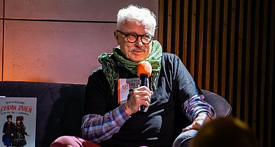 Krzysztof Deszczyński na żółtej sofie w Książnicy Beskidzkiej