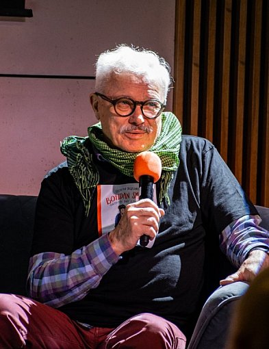 Krzysztof Deszczyński na żółtej sofie w Książnicy Beskidzkiej