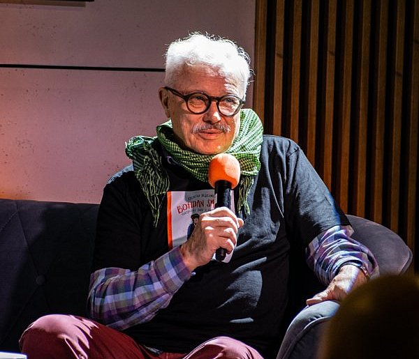 Krzysztof Deszczyński na żółtej sofie w Książnicy Beskidzkiej