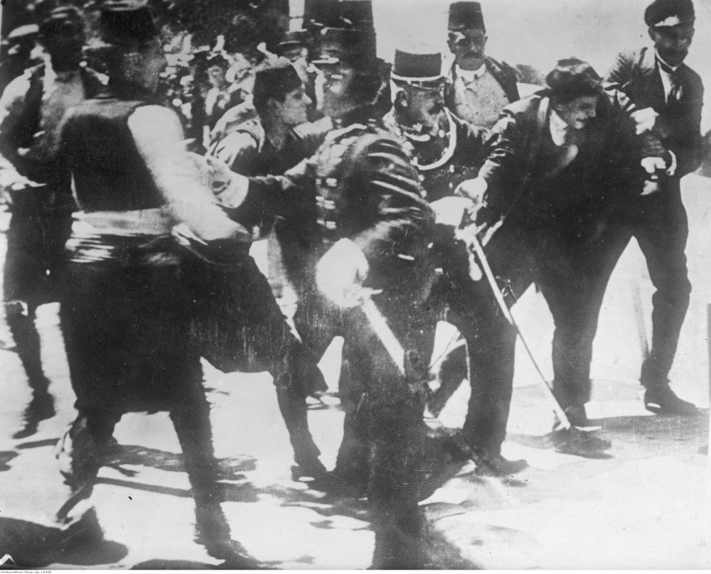 Zamach w Sarajewie. Reprodukacja fografii, przedstawiającej aresztowanie Ferdinanda Behra, osłaniającego Gavrilo Principa przed linczem. Fotografię wykonano w dniu zamachu 28 czerwca 1914 roku.