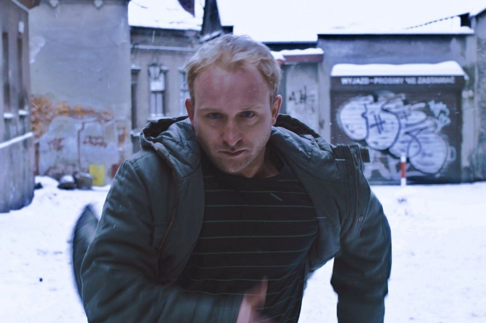 Kard z filmu Kret - Borys Szyc na tle uliczki Schodowej